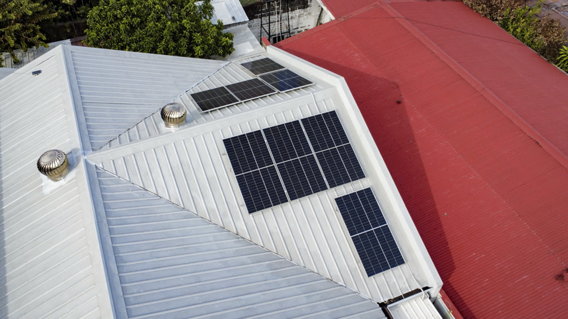 Aerial view of Armand Sia’s expanded rooftop solar array on his home’s grey and red roof