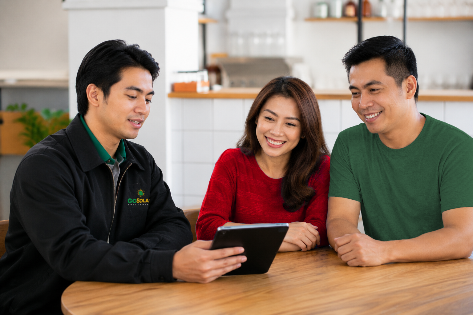 A GoSolar Philippines consultant showing a tablet to a Filipino couple at their dining table while discussing a home solar plan